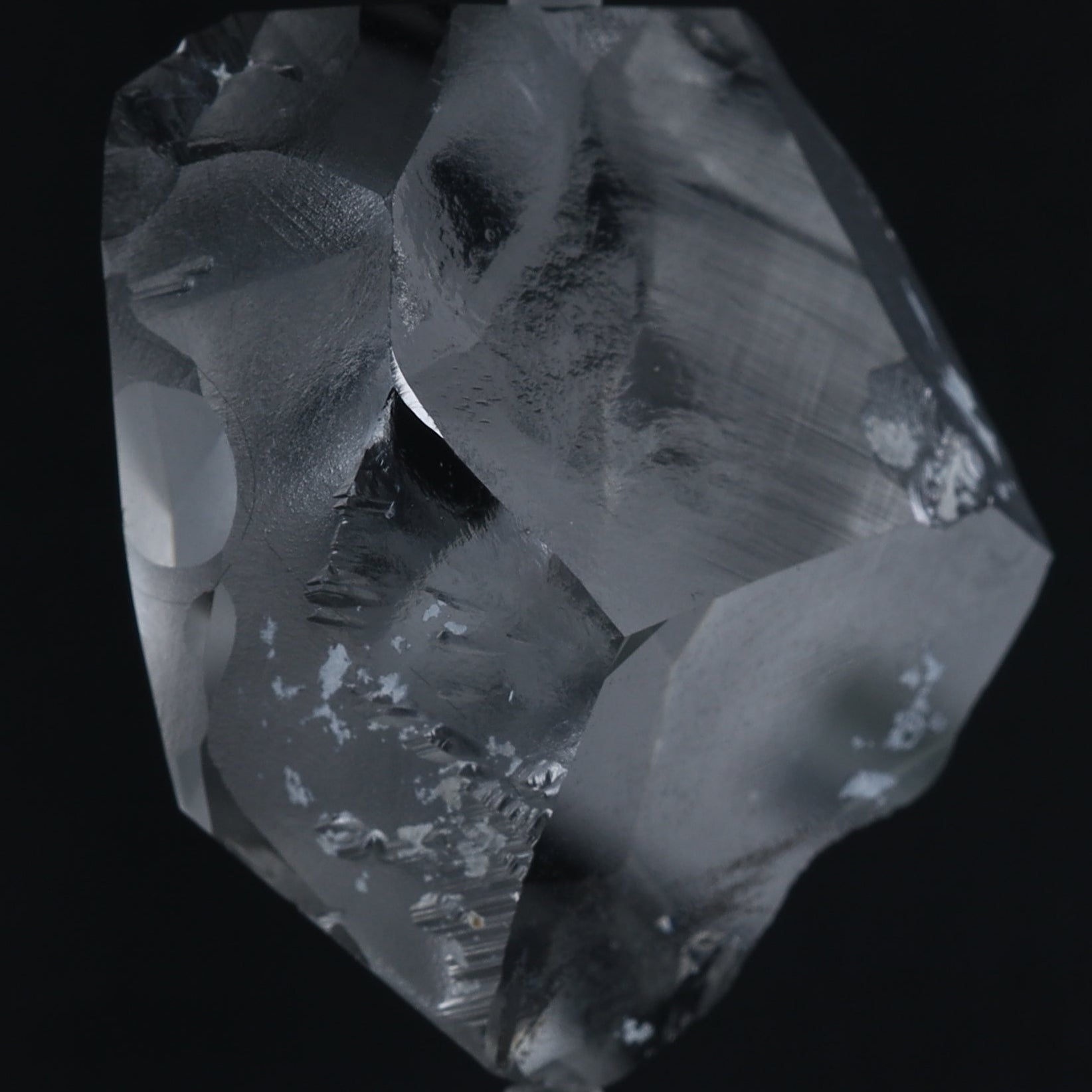 A raw, unpolished clear DIAMOND crystal with natural inclusions and rough edges, shown against a solid black background.